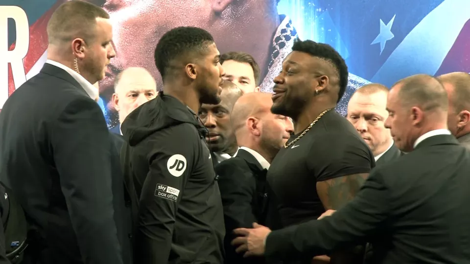 Anthony Joshua and Jarrell Miller standing face to face at a press conference