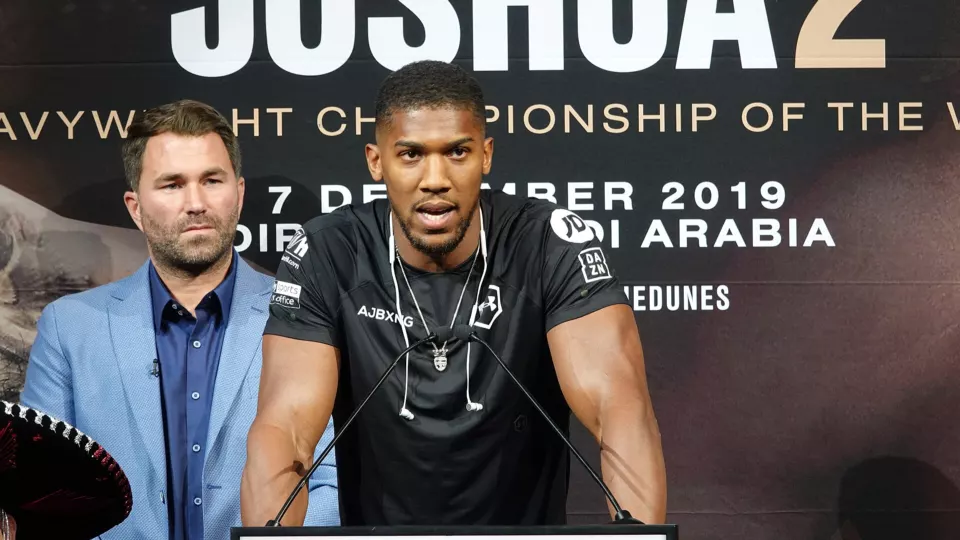 Anthony Joshua speaking at a press conference with Eddie Hearn behind him