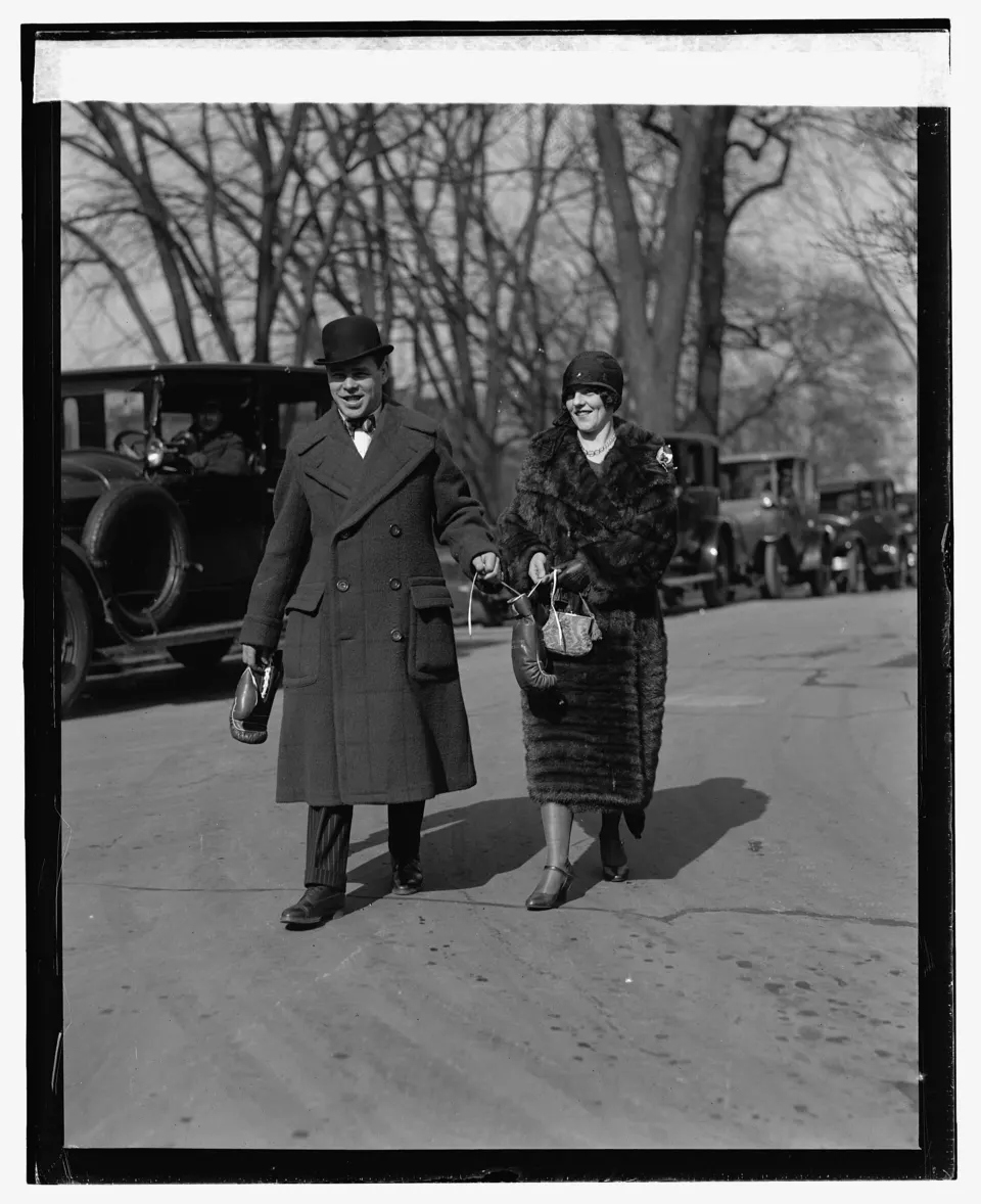 Mickey Walker in a suit standing with his wife outside the White House