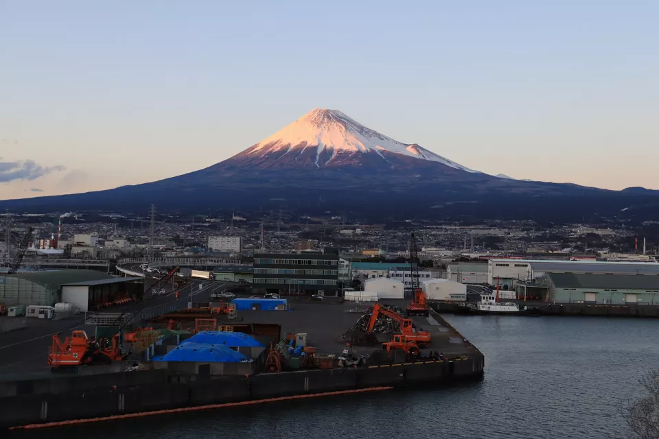 Snow-capped Mount Fuji rising behind the buildings of Fuji City